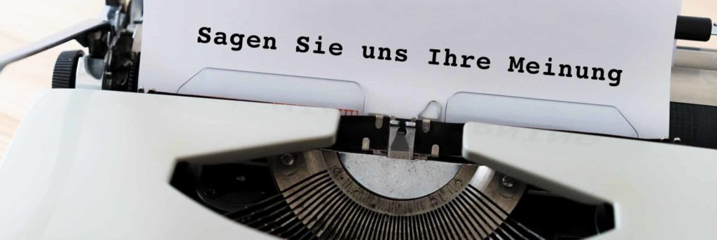 Schreibmaschine mit Text auf Blatt "Sagen Sie uns Ihre Meinung"